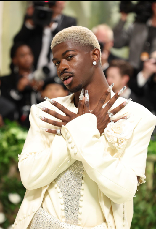 Lil Nas X Met Gala 2024 wearing a cream crystal-covered Luar outfit on the red carpet.